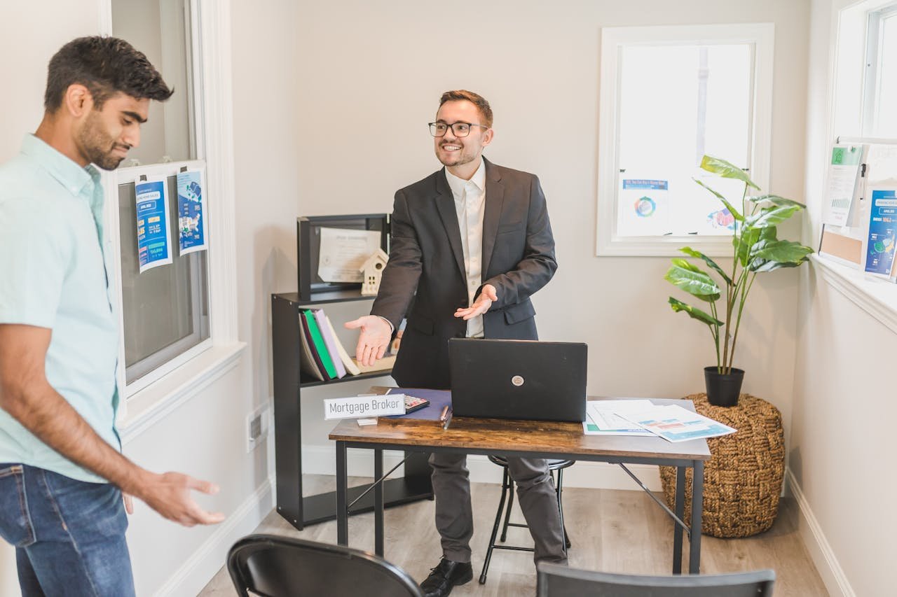 A professional business interaction in a modern office with a mortgage broker and client.